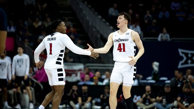 Cincinnati Bearcats guard Simas Lukosius (41) celebrates with Cincinnati Bearcats guard Day Day Thomas (1) after hitting a 3-point basket in the second half of the Big 12 Conference tournament between Cincinnati Bearcats and West Virginia Mountaineers at T-Mobile Center in Kansas City, Mo., on Tuesday, March 12, 2024.